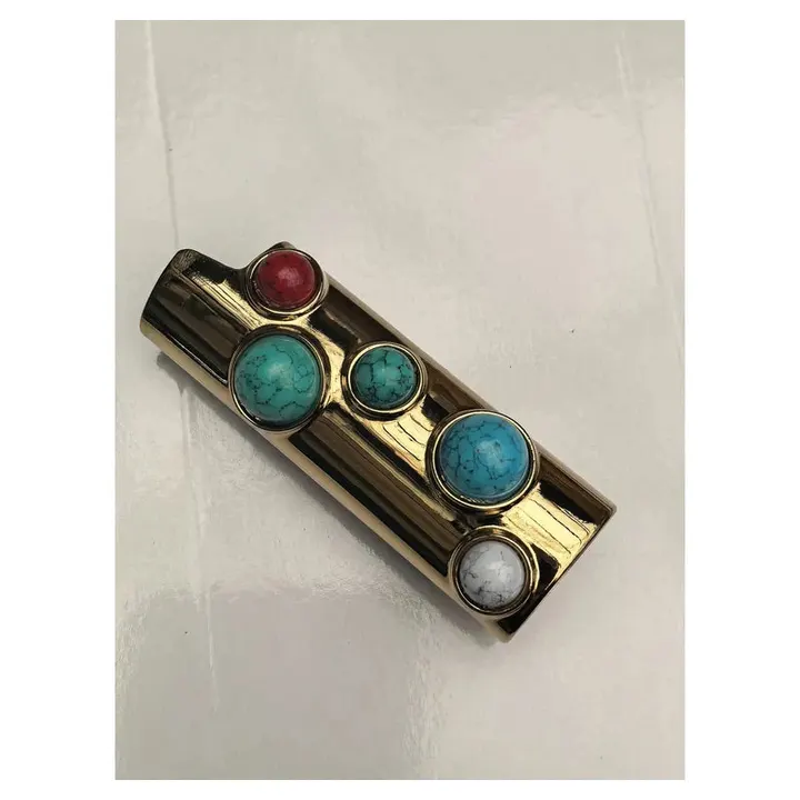 porta-isqueiro-bic-luxo-pedras-turquesa-detalhe-pedras - Detalhe das pedras turquesa, coral e branco no porta-isqueiro BIC luxo dourado.